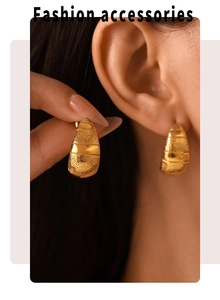 Vue détaillée de boucles d'oreilles dorées en croissant aux textures polies et mates