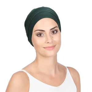 Detailed close-up of dark green pleated turban hat showing fabric texture and pleats