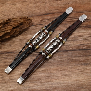 Retro multi-layer leather bracelets with tribal metal beads on a natural wood background