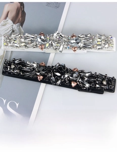 Detailed close-up of crystal rhinestones on elastic belt over fashion magazine