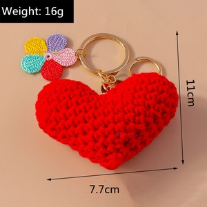 Detail view of red knitted heart keychain with colorful flower and size measurements