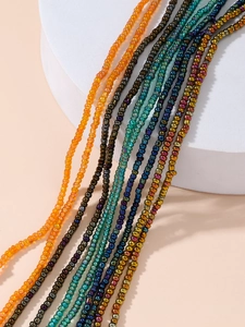 Macro detail of Bohemian colorful seed bead waist chains on a white pedestal display