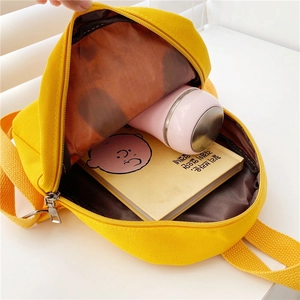 Interior detail of yellow canvas toddler backpack holding a water bottle and A5 book