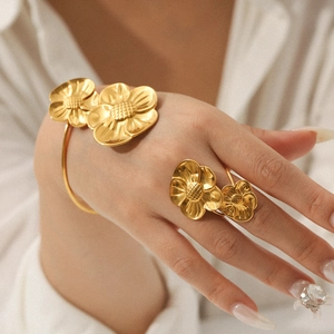 Detail of 18K gold-plated stainless steel floral bracelet and ring set on model