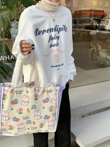 Canvas tote bag with purple trim and fuzzy handles featuring a cute garden rabbit print
