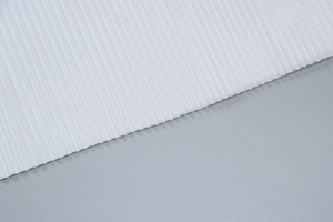 Detailed close-up of premium white ribbed fabric texture with vertical striped patterns