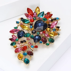 Ornate gold alloy brooch with a large heart-shaped blue gem and colorful crystal leaves
