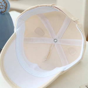 Detailed interior of a beige baby baseball cap showing seams and white sweatband