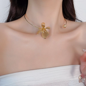 Close-up of a designer gold flower choker necklace worn on a model's neck