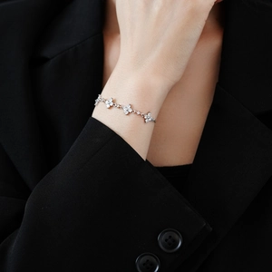 Detailaufnahme eines silbernen Schneeflocken-Armbands mit Zirkonia-Steinen an einem Model