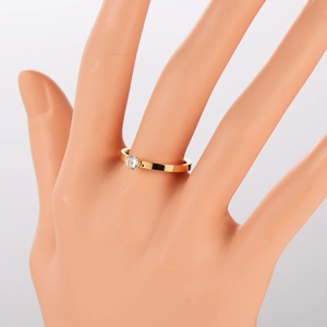 Sparkling gold zircon ring with Roman numeral engravings on a model's finger