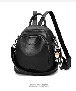 Detail view of black litchi pattern faux leather backpack with plush doll pendant