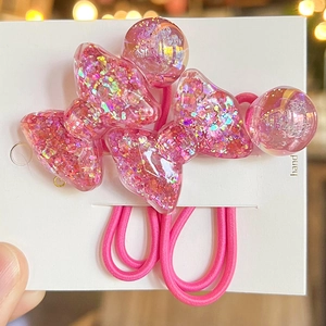 Detail of pink hair ties with resin butterfly charms and glitter inside for girls
