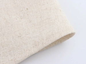 Vue macro de la texture du tissu en lin beige et des motifs tissés d'une jupe longue trapèze