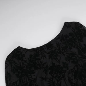 Detailed close-up of black floral burnout pattern on translucent mesh fabric dress