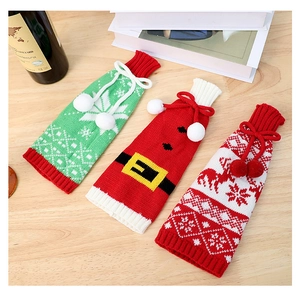 Detailed view of three festive knitted Christmas wine bottle covers with snowflake patterns