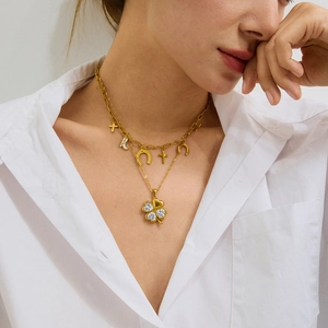 Gold double-layered necklace with clover zircon pendant and charms on model neck