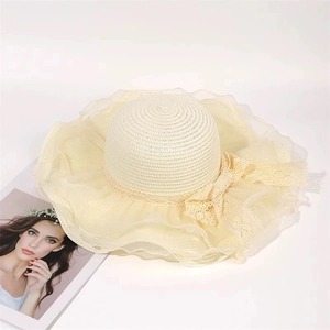 Elegant wide brim straw sun hat with lace bow and organza ruffles in cream beige color