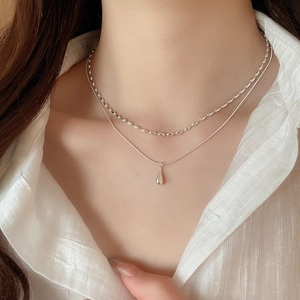 Close-up of double-layer silver water drop pendant necklace on model with white blouse