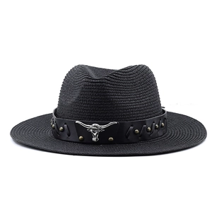 Detail of black straw cowboy hat featuring leather band and metallic longhorn bull emblem