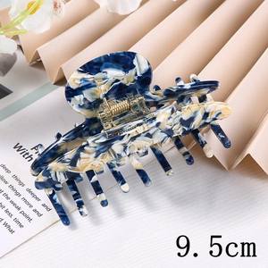 Detail view of 9.5cm acetate hair claw clip with blue and white marble pattern