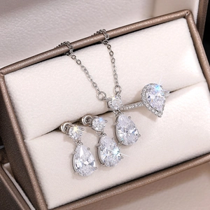 Détail du parure collier, boucles d'oreilles et bague en zircone étincelante dans un écrin