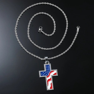 Détail du pendentif croix argentée avec motif drapeau américain et cristaux sur chaîne