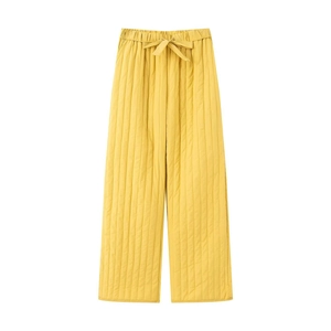 Detail of ginger yellow quilted wide-leg pants with elastic drawstring waist and vertical seams