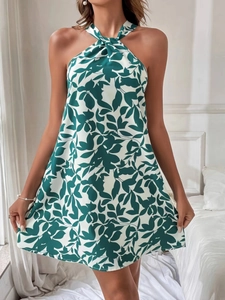 Detail of floral halter neck dress with green leaf print and tiered ruffle hemline