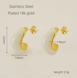 Détail de boucles d'oreilles en C en acier doré 18 carats avec résine ivoire