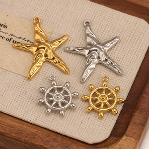 Detailed view of nautical starfish and rudder pendants in gold and silver finish