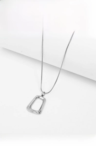Close-up of geometric square hollow pendant on a fine snake chain necklace