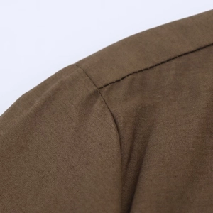 Close-up of high-quality double stitching on a brown poplin shirt dress fabric