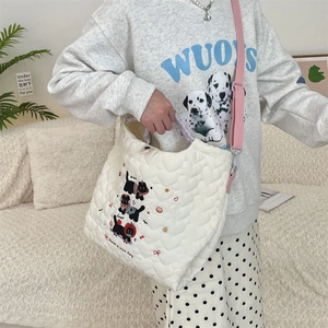 Detail of white heart-quilted tote bag featuring cute black cat embroidery and pink strap