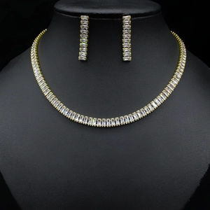 Detail of gold zircon necklace and earrings set displayed on a professional black bust