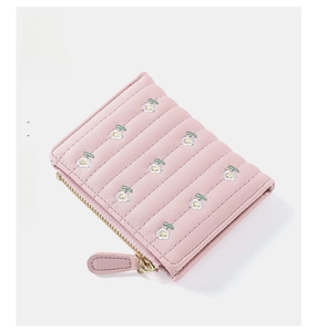 Detailed view of pink mini wallet featuring floral embroidery and golden zipper closure