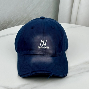 Close-up of navy cotton baseball cap featuring vintage distressed holes and MJ embroidery