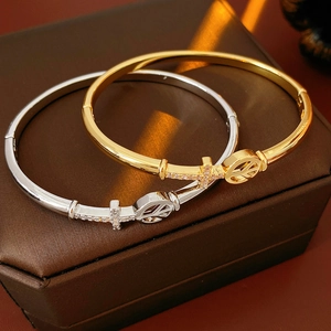 Detailed macro view of gold and silver cross bangles with micro-pave zircons