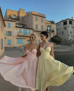 Detail of strapless fishtail dresses with corsets and large satin bows on the back