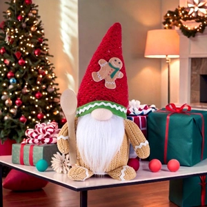 Detail of Christmas gingerbread gnome plush toy with white beard and wooden spoon prop