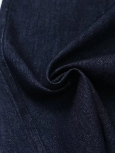 Gros plan détaillé montrant la texture du denim bleu foncé et la qualité du tissage sergé