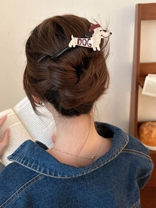 Détail d'une pince à cheveux teckel sur des cheveux tressés dans un cadre chaleureux