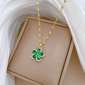 Gold-plated titanium steel necklace with a green rotating clover pendant on a gift box