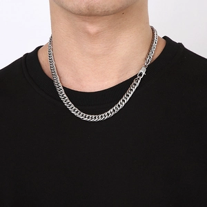 Gros plan d'un collier chaîne gourmette en acier titane argenté sur un modèle