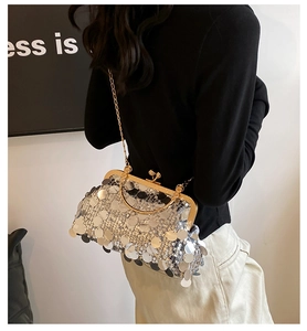 Detail of silver sequined crossbody bag with golden metal frame and chain strap