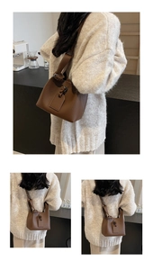 Close-up of the brown bucket bag showing the soft pebbled leather texture and metal buckle
