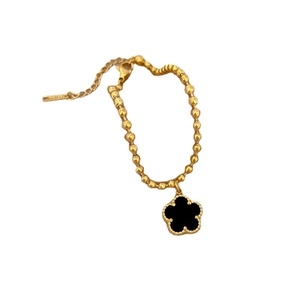 Golden titanium steel beaded bracelet with black clover pendant on a white background
