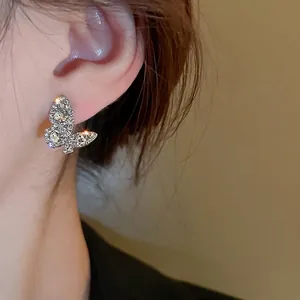 Elegant butterfly stud earring with shimmering crystal inlay on female model side profile