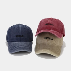 Three colors of washed cotton baseball caps with HELLO embroidery and vintage textures