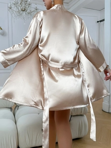 Détail du peignoir en satin champagne montrant la texture luxueuse et la ceinture nouée